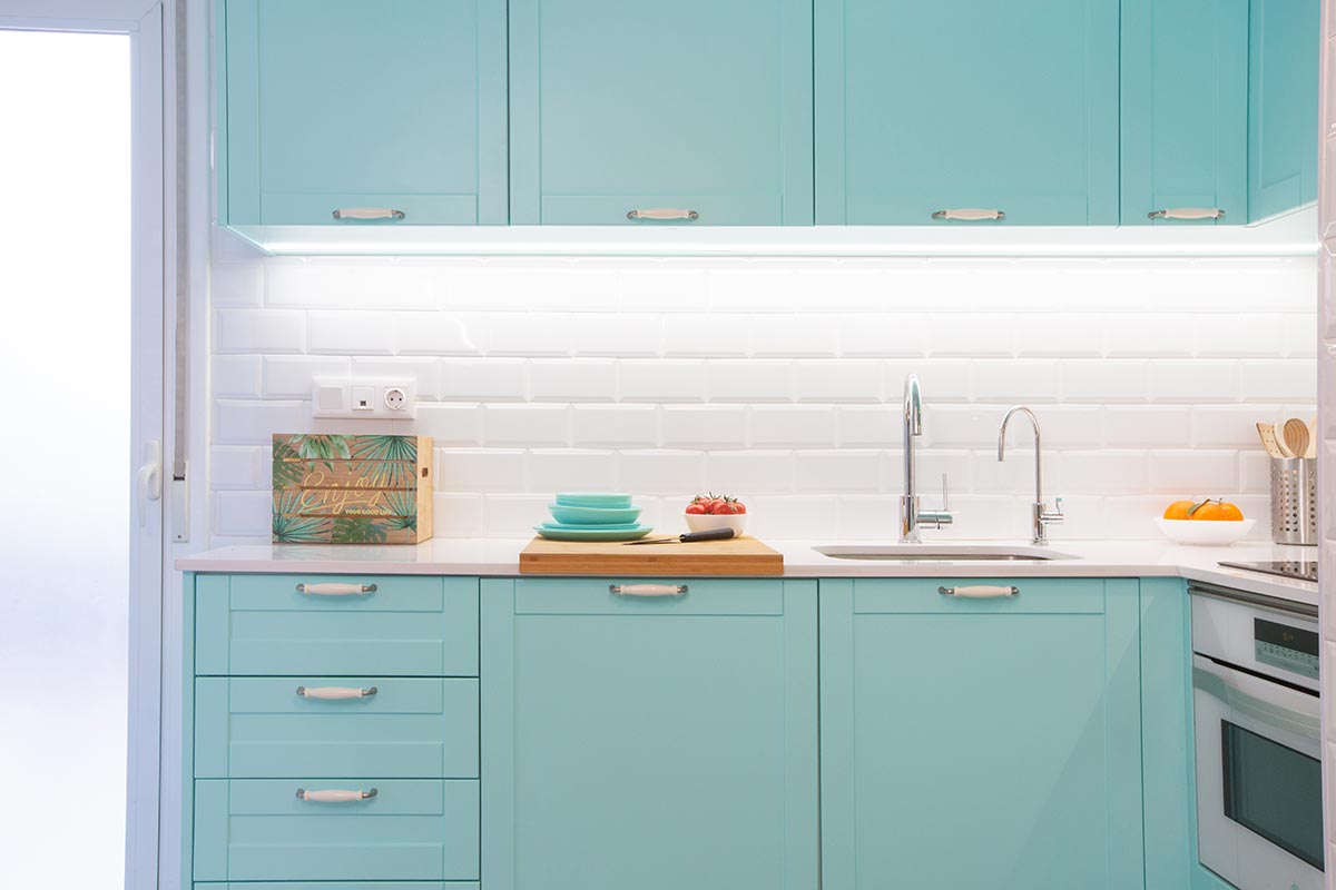 Muebles de cocina color aguamarina y azulejos blancos